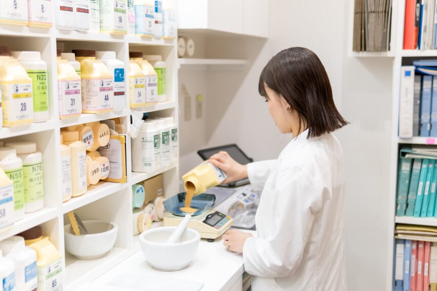 漢方ツヅノ薬局田町店のスタッフが漢方薬を調合している写真